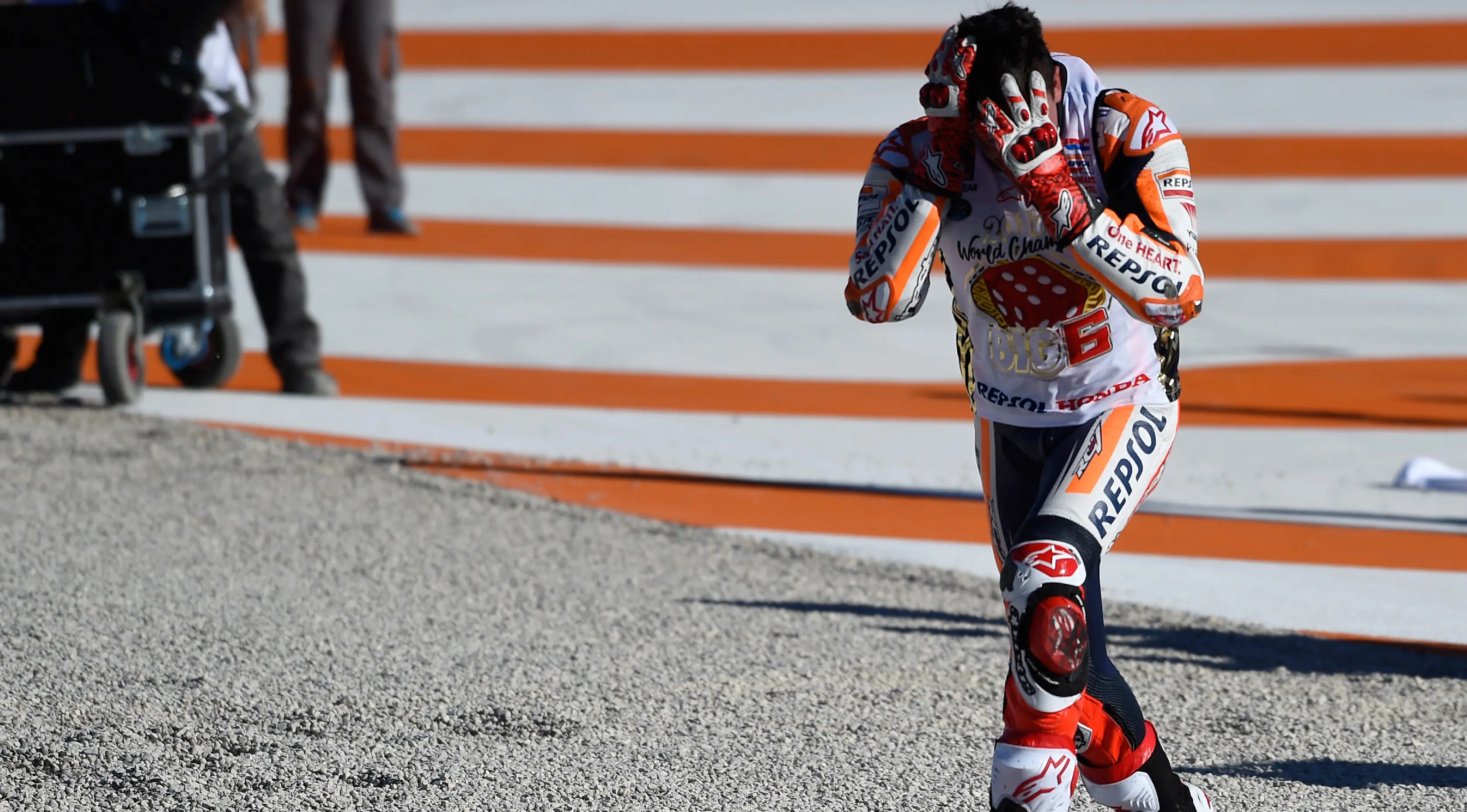 Pembalap Spanyol Repsol Honda, Marc Marquez meluapkan kegembiraannya sambil memegang kepala setelah memastikan gelar juara dunia pada balapan MotoGP Valencia di Sirkuit Ricardo Tormo, Valencia (12/11). (AFP PHOTO / Jose Jordan)