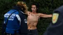 Seorang aktivis femen ditangkap polisi saat melakukan aksi telanjang dada memprotes penggalian makam diktator Spanyol Francisco Franco selama pertemuan tahunan di Madrid, Spanyol (24/11/2019). Aksi ini sekaligus memperingati kematian Francisco Franco. (AFP/Oscar Del Pozo)