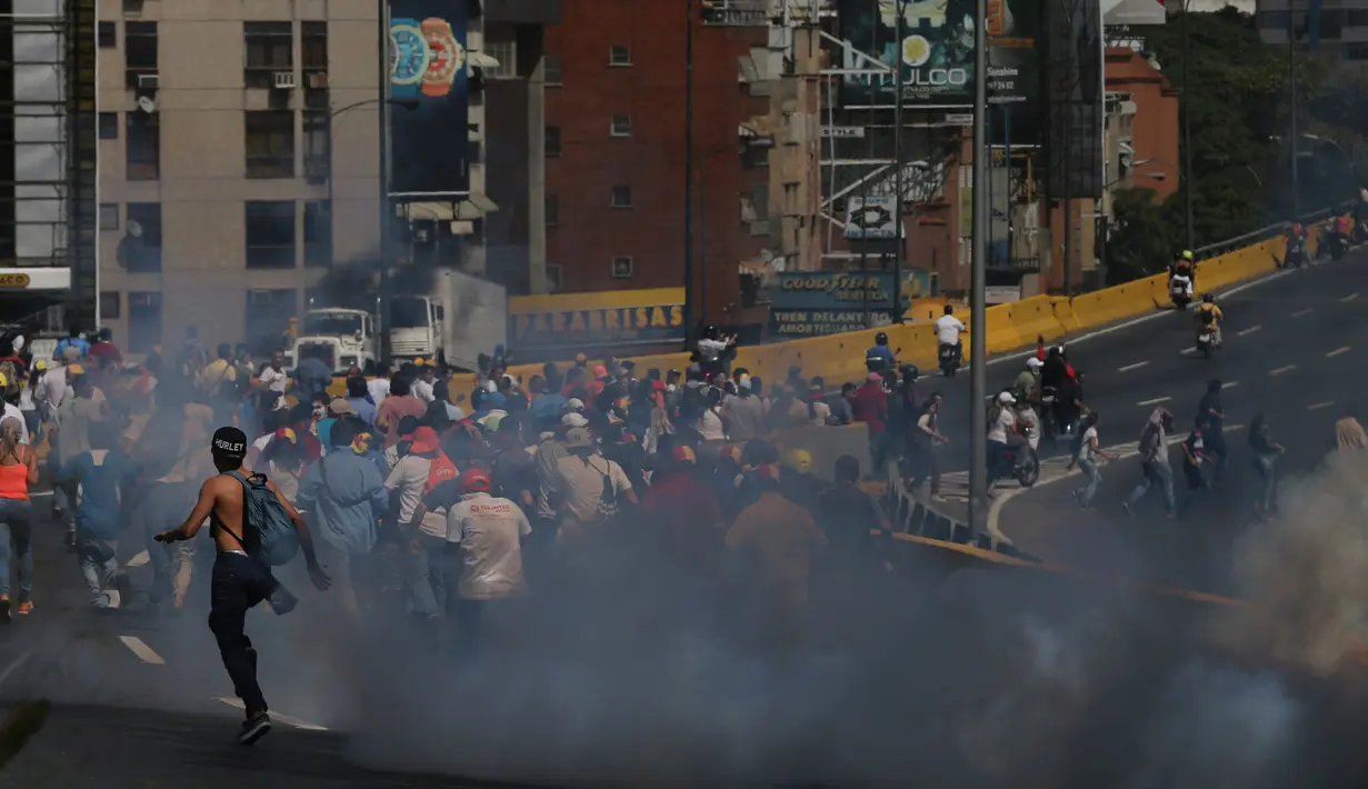 Kericuhan pecah antara demonstran dengan pasukan polisi di Caracas, Venezuela, (4/4). Para demonstran berusaha untuk menemani anggota parlemen oposisi dalam sesi wacana penghapusan Mahkamah Agung. (AP Photo / Fernando Llano)