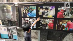 Warga melihat pameran foto jurnalistik karya pewarta foto Indonesia Tangerang di kawasan Pasar Lama, Tangerang, Minggu (30/5/2021). Pameran foto bertajuk meredanya Covid-19 ini bertujuan agar masyarakat dapat mengenal bahaya Covid-19 yang tengah mewabah di Indonesia.  (Liputan6.com/Angga Yuniar)