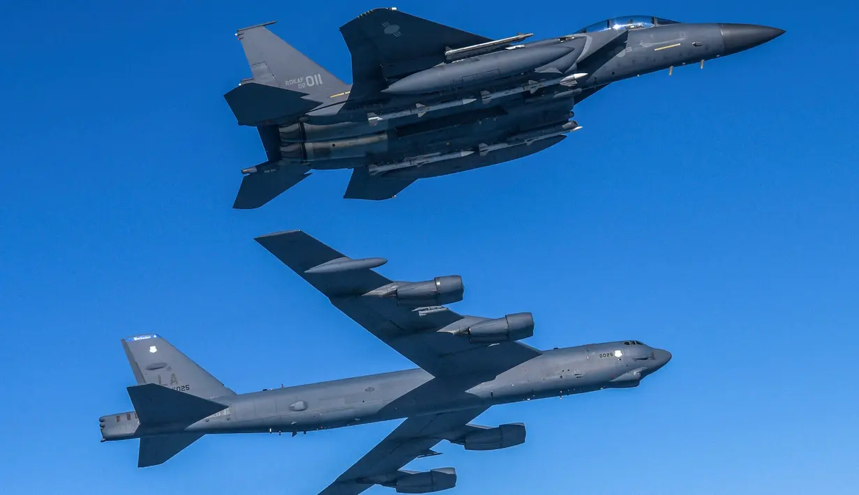 Pesawat Stratofortress B-52H Angkatan Udara Amerika Serikat (bawah) terbang dalam formasi dengan pesawat tempur F-15K Angkatan Udara Korea Selatan di atas laut barat Semenanjung Korea saat latihan udara bersama di Korea Selatan, Senin (6/3/2023). Korea Utara menilai latihan militer Amerika Serikat dan Korea Selatan telah meningkatkan ketegangan yang mengancam pihak-pihak tertentu bisa lepas kendali. (South Korea Defense Ministry via AP)