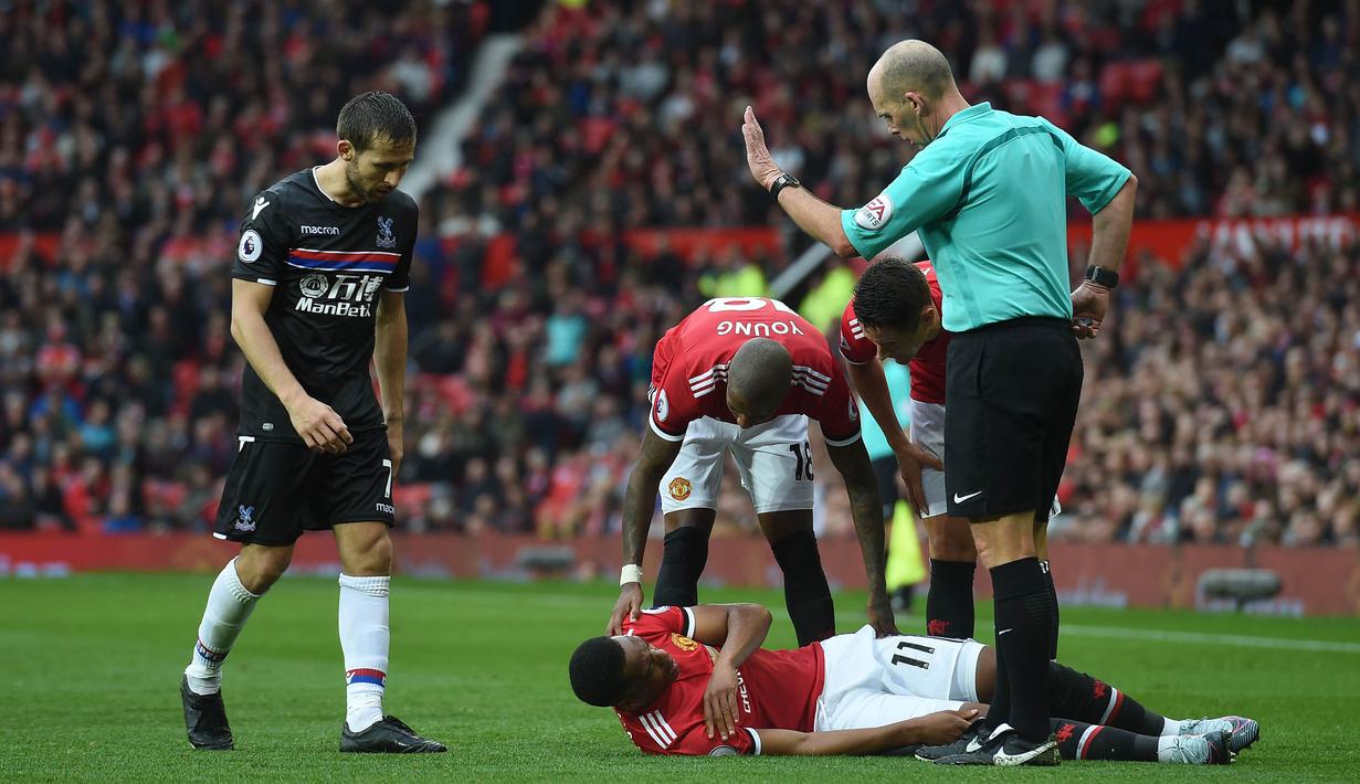 Gelandang Manchester United, Anthony Martial, tampak kesakitan saat melawan Crystal Palace pada laga Premier League di Stadion Old Trafford, Manchester, Sabtu (30/9/2017). MU menang 4-0 atas Palace. (AFP/Paul Ellis)