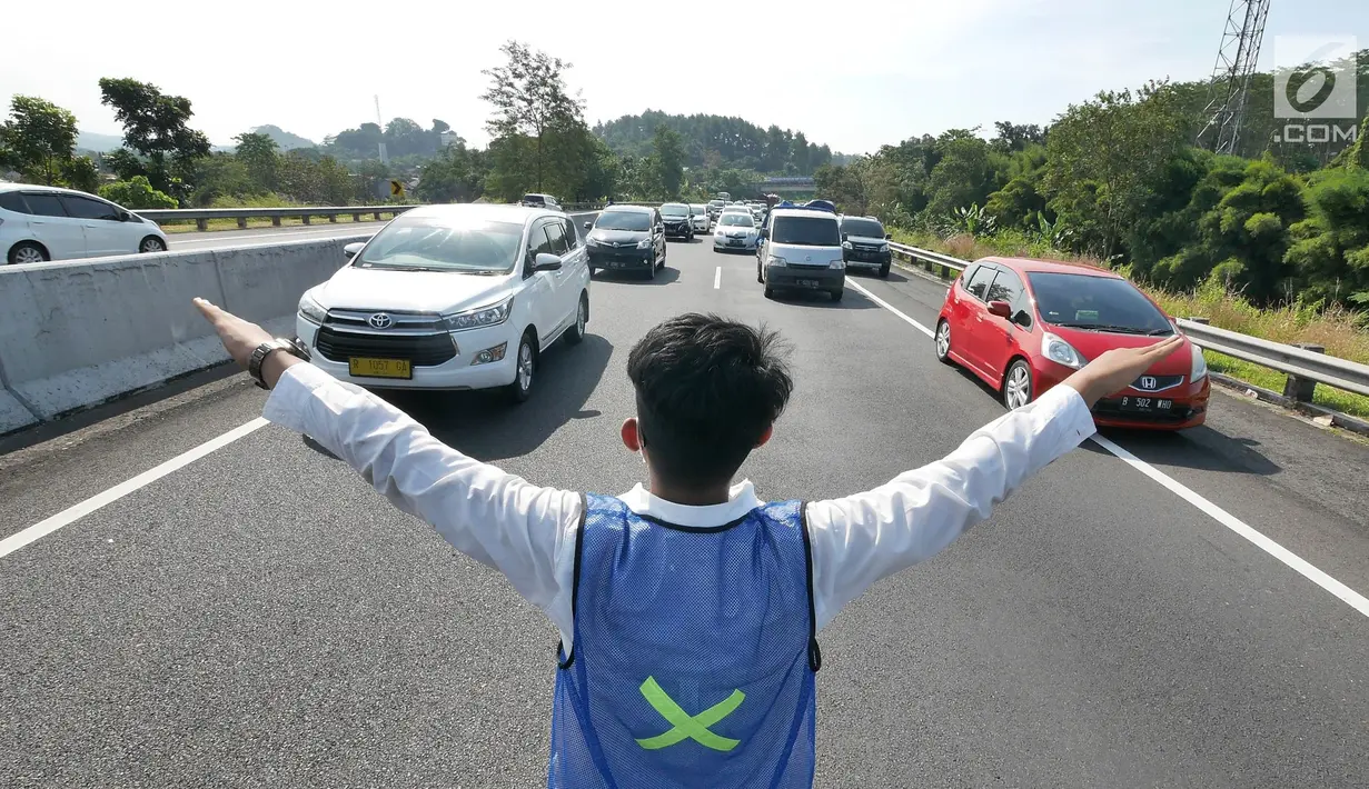 Petugas mengatur pemberlakukan jalur contra flow di ruas tol Semarang-Bawen, Jawa Tengah, Jumat (31/5/2019). Jasa Marga memberlakukan rekayasa lalu lintas sistem lawan arus dari Km 426 hingga Km 433 ruas tol Semarang-Bawen guna mengurai kepadatan kendaraan pemudik. (Liputan6.com/Herman Zakharia)