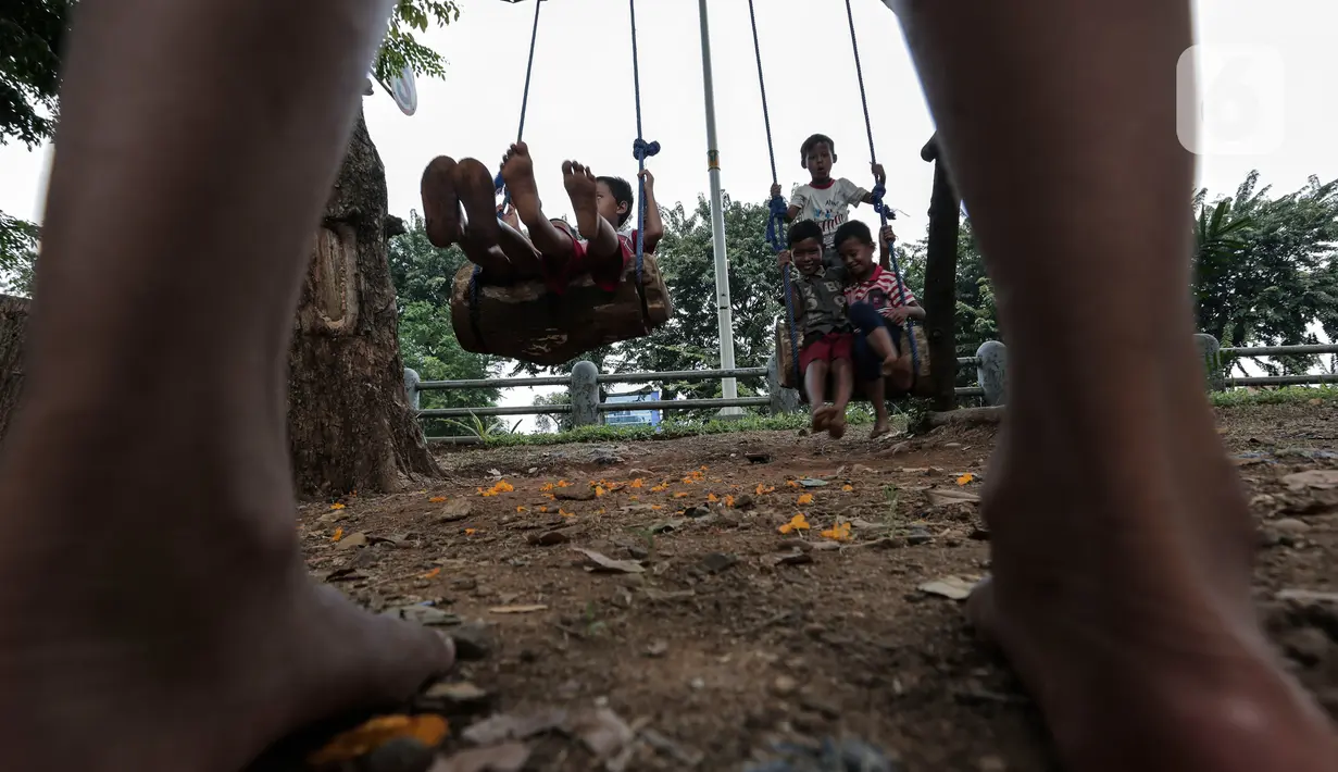 Anak-anak bermain di Taman Tomang Rawa Kepa, Jakarta, Minggu (21/6/2020). Lokasi tersebut menjadi salah satu tempat alternatif liburan warga untuk menghilangkan kebosanan di tengah masa PSBB transisi. (Liputan6.com/Johan Tallo)