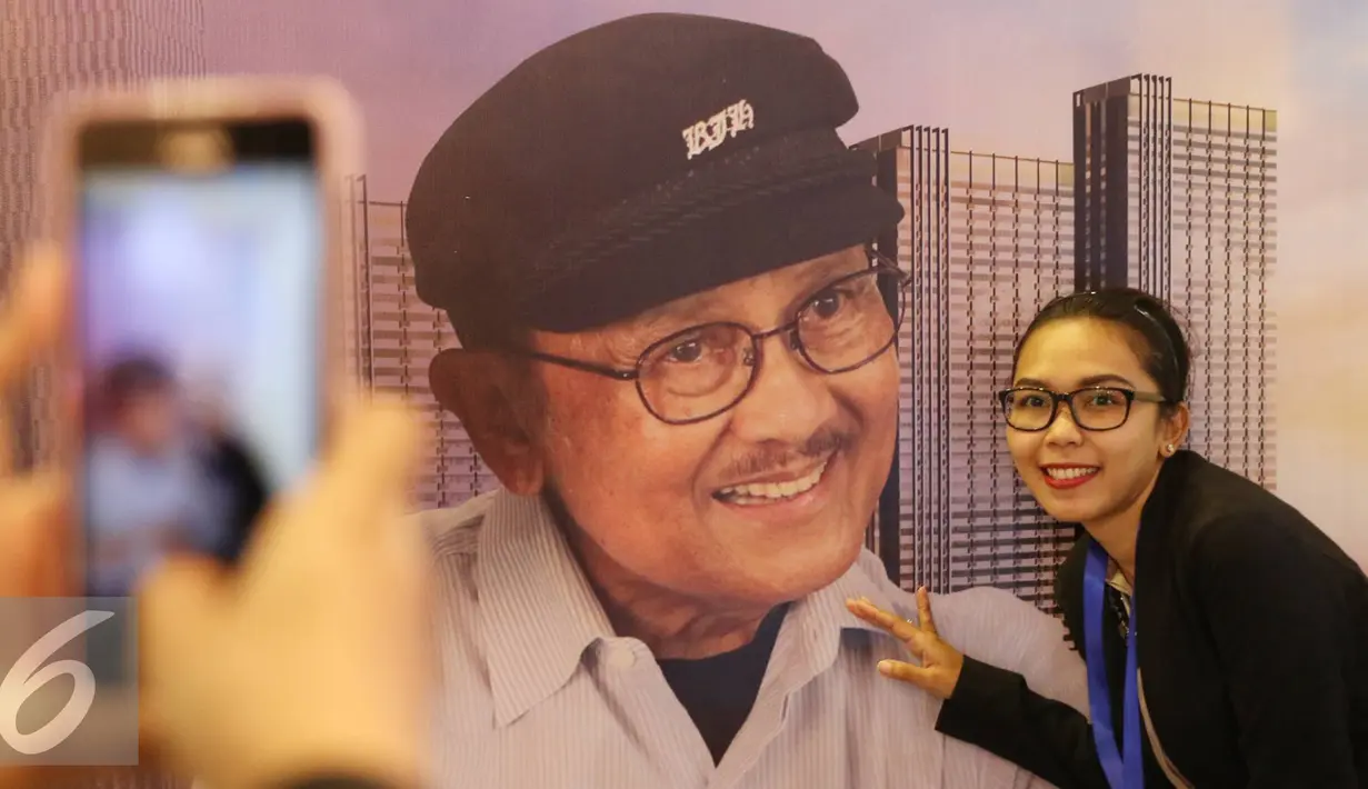 Pengunjung foto di depan poster Presiden ke-3 RI, Bacharuddin Jusuf Habibie saat pembukaan Habibie Festival di Museum Nasional, Jakarta, Kamis (11/8). Acara diadakan dalam rangka merayakan ulang tahun B.J Habibie ke-80. (Liputan6.com/Immanuel Antonius)