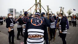 Anggota Asosiasi Pelestarian Pemadam Kebakaran Edo memegang tangga bambu saat melakukan teknik pemadam kebakaran tradisional Jepang saat latihan pemadam kebakaran Tahun Baru di Tokyo, Jepang, 6 Januari 2022. (Behrouz MEHRI/AFP)