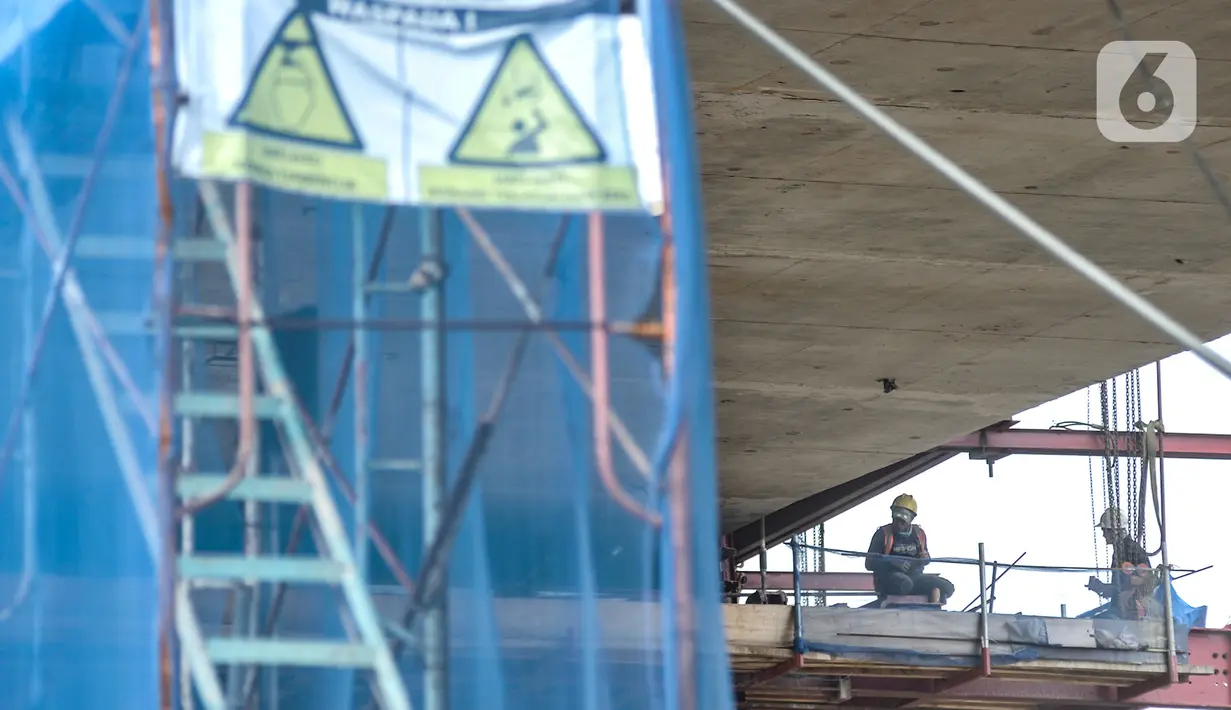 Aktivitas pekerja saat menyelesaikan proyek pembangunan jalur lintas atas (flyover) Cakung, Jakarta, Kamis (17/12/2020). Proyek Flyover Cakung saat ini telah mencapai 94 persen dan sedang menyelesaikan pemasangan balok girder pada bentang yang melintasi rel kereta api. (merdeka.com/Iqbal Nugroho)