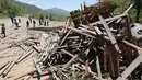 Para wartawan asing berdiri dekat puing-puing setelah ledakan situs uji nuklir Korea Utara di Punggye-ri, Kamis (24/5). Para jurnalis asing  dari Korea Selatan, AS, China, Rusia, dan Inggris, diundang dalam penghancuran situs. (Korea Pool/Yonhap via AP)