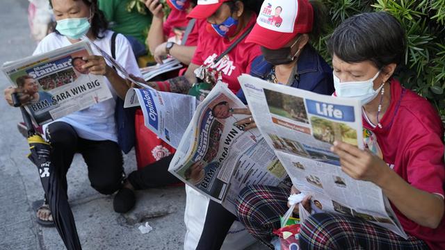 Koran yang menampilkan berita utama tentang Ferdinand "Bongbong" Marcos Jr. dan pasangannya Wali Kota Davao City Sara Duterte pada Pilpres Filipina 2022. (Foto AP/Aaron Favila)