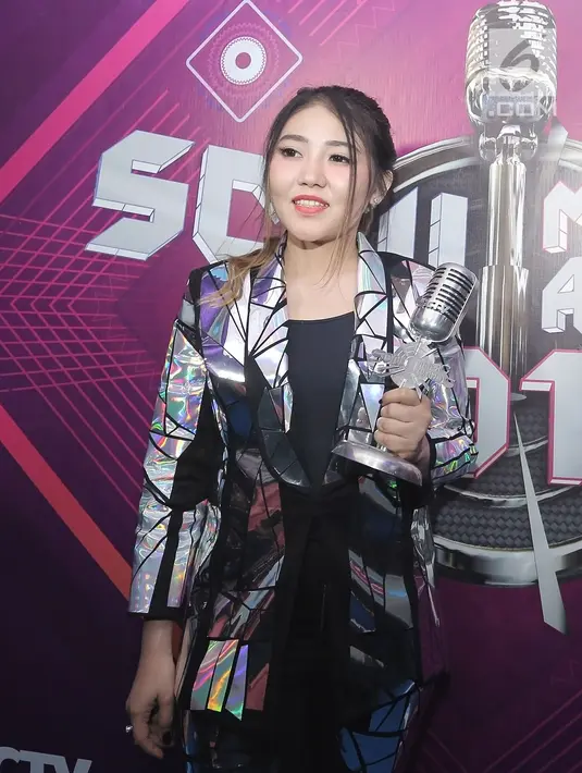 Penyanyi dangdut Via Vallen menunjukkan piala penghargaan usai acara SCTV Music Awards 2019 di Studio 6 Emtek City, Jakarta, Jumat (26/4). Via Vallen memboyong gelar Kategori Lagu Pop Paling Ngetop melalui "Meraih Bintang" yang sempat menjadi Theme Song Asian Games 2018. (Fimela.com/Bambang E. Ros)