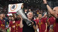 Pelatih AS Roma Jose Mourinho memegang trofi setelah timnya memenangkan partai final Liga Konferensi Eropa UECL musim 2021-222 melawan Feyenoord di Arena Kombetare, Tirana, Albania, Kamis (26/5/2022) dini hari WIB. 'Serigala Ibu Kota' menang 1-0 lewat gol Nicolo Zaniolo dan adalah gelar pertama AS Roma sejak 14 tahun terakhir. (OZAN KOSE / AFP)