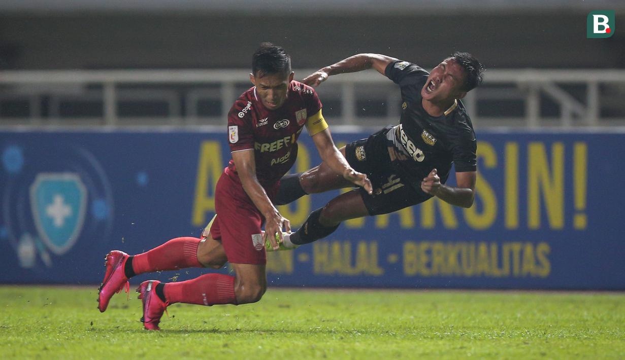 Pemain Martapura Dewa United, Selamet Budiono (kanan) terlibat benturan dengan pemain Persis Solo, Chrystna Bhagascara dalam laga semifinal Liga 2 2021 di Stadion Pakansari, Bogor, Senin (27/12/2021). (Bola.com/Bagaskara Lazuardi)