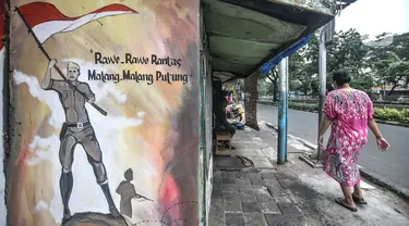 Warga melintas di depan mural bertemakan Pancasila di Kampung Pancasila kawasan Galur, Johar Baru, Jakarta, Selasa (1/6/2021). Kelurahan Galur membuat Kampung Pancasila yang dihiasi mural sebagai bentuk mengingatkan masyarakat akan Pancasila sebagai dasar negara. (merdeka.com/Iqbal S. Nugroho)