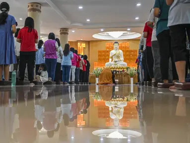 Umat Buddha melaksanakan ibadah pada perayaan hari raya Waisak di Vihara Sakyamuni, Banda Aceh, Aceh, Kamis (23/5/2024). (CHAIDEER MAHYUDDIN / AFP)