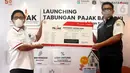 Direktur Ritel dan Syariah Bank DKI Babay Parid Wazdi (kiri) memberikan Sertifikat Kepemilikan Tabungan Pajak kepada Wakil Kepala Bapeda DKI, Elvarinsa pada peluncuran Tabungan Pajak Bank DKI di Jakarta (30/3/2022). Melalui Tabungan Pajak, wajib pajak dapat menabung terjadwal. (Liputan6.com/HO/BDKI)