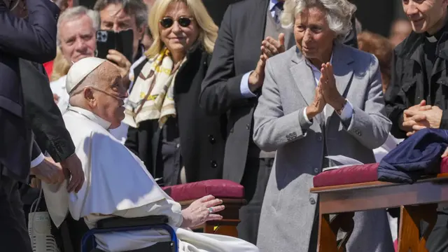 Paus Fransiskus disambut dengan tepuk tangan oleh umat saat muncul mendadak di akhir misa di Lapangan Santo Petrus di Vatikan, Minggu (6/4/2025).