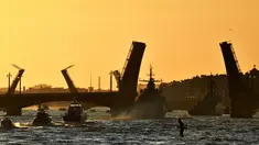 Kapal perang Rusia berlayar di sungai Neva melalui jembatan gantung selama latihan parade Angkatan Laut di Saint Petersburg pada awal 16 Juli 2023. (AFP/Olga Maltseva)