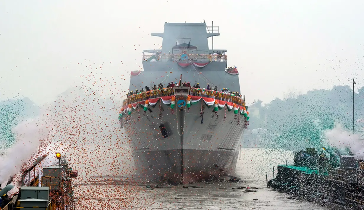 Confetti dan asap berwarna bendera nasional India menandai masuknya INS Vindhyagiri ke Sungai Hooghly di Kolkata, India, Kamis (17/8/2023). INS Vindhyagiri merupakan kapal perang baru untuk angkatan laut India. (AP Photo/Bikas Das)
