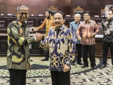 Ketua Mahkamah Konstitusi (MK) terpilih Suhartoyo (kanan) berjabat tangan dengan Wakil Ketua MK Sadil Isra (kiri) usai memberikan keterangan pers di Gedung Mahkamah Konstitusi, Jakarta, Kamis (9/11/2023). (Liputan6.com/Angga Yuniar)