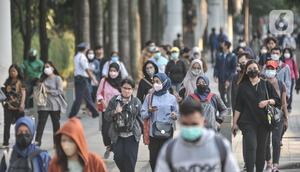 Pekerja melintas di trotoar Jalan Jenderal Sudirman saat jam pulang kantor, Selasa (4/1/2022). PPKM di Jakarta kembali diperpanjang oleh pemerintah pusat terhitung 4-17 Januari 2022 dari sebelumnya di Level 1 kini menjadi Level 2. (merdeka.com/Iqbal S. Nugroho)