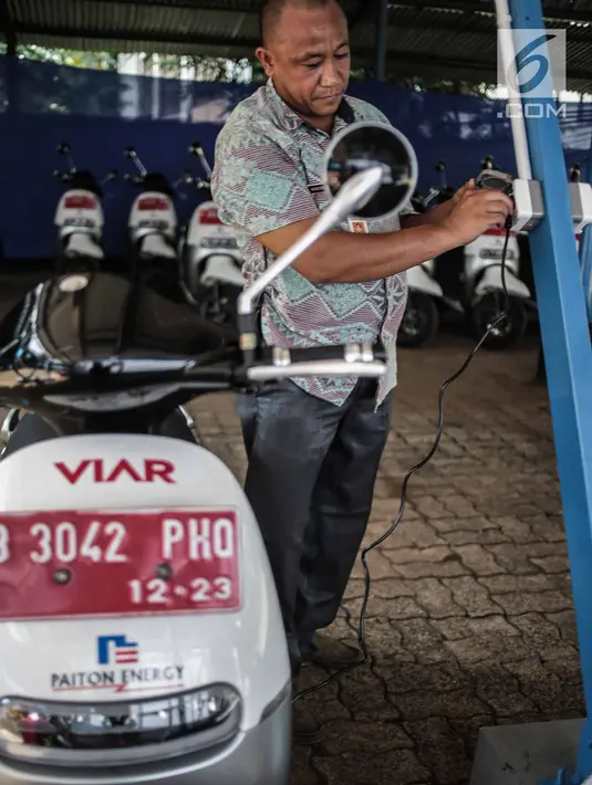 Petugas menunjukan indikator pengecasan baterai motor listrik pengisian daya motor listrik di Taman Marga Satwa Ragunan, Jakarta, Kamis (13/12). Pemprov DKI menerima hibahan 50 unit motor listrik Viar Q1. (Liputan6.com/Faizal Fanani)