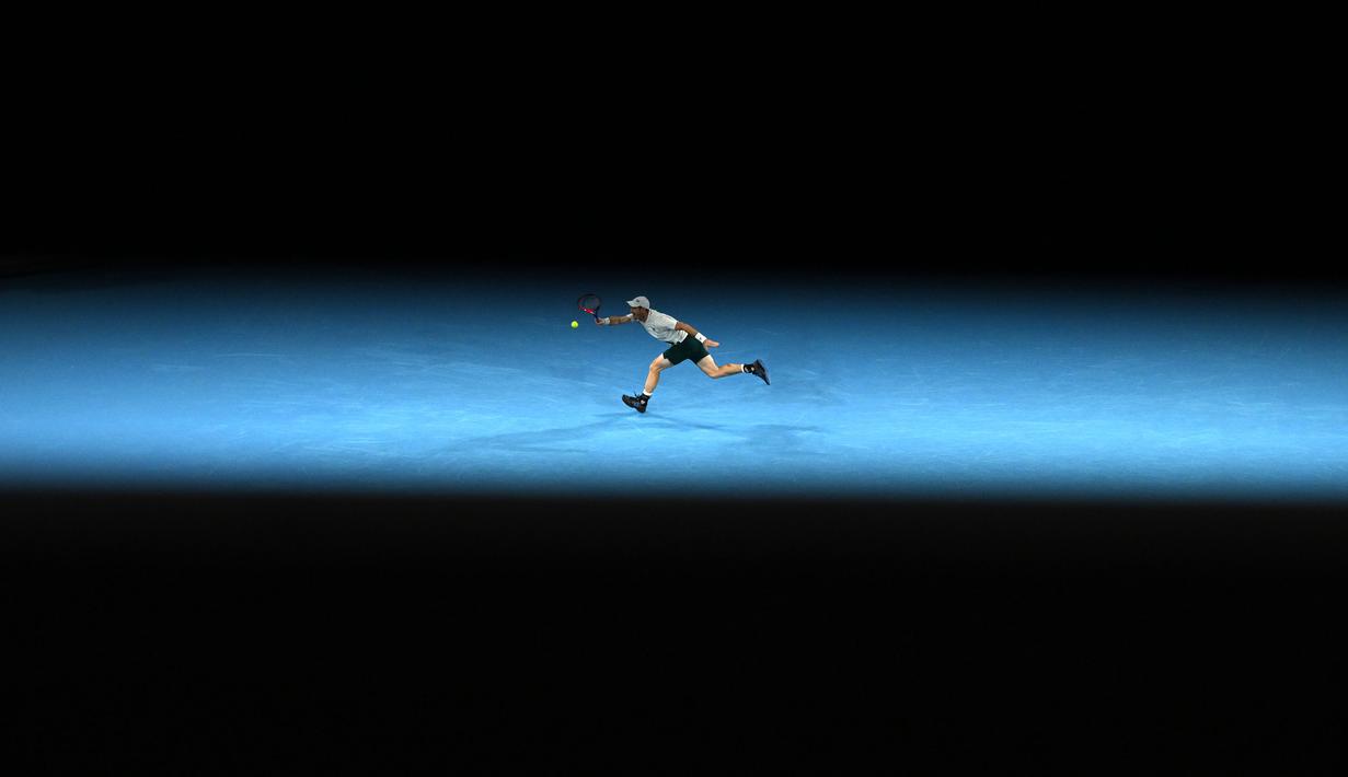 Petenis Inggris, Andy Murray mengembalikan bola ke arah petenis Australia, Thanasi Kokkinakis saat laga putaran ketiga Australian Open 2023 di Melbourne, Australia, Jumat (20/01/2023). (AFP/Manan Vatsyayana)