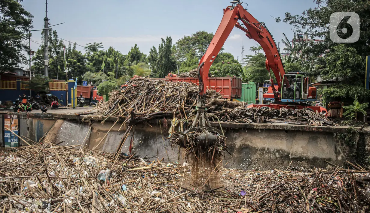 Pekerja kebersihan mengangkat sampah yang menumpuk di pintu air Manggarai, Jakarta, Selasa (22/9/2020). Tingginya curah hujan membuat kiriman sampah menumpuk di pintu air Manggarai. (Liputan6.com/Faizal Fanani)