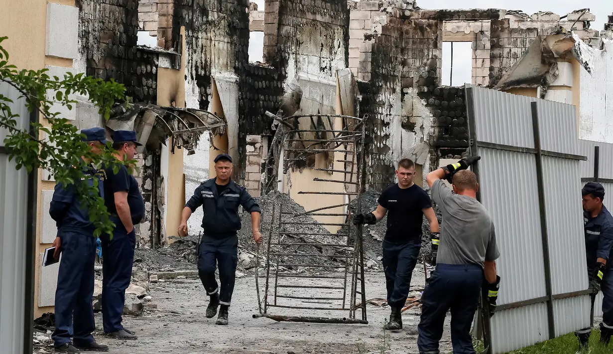Pemadam kebakaran berada di bangunan perumahan yang menampung kelompok usia lanjut di sebuah desa dekat Kiev, Ukraina, Minggu (29/5). Sedikitnya 17 orang tewas setelah api menghanguskan bangunan yang dihuni oleh 35 orang tersebut. (REUTERS/Gleb Garanich)
