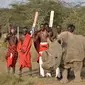 Pejuang Maasai berpose dengan satu-satunya pejantan dari tiga badak putih terakhir di dunia bernama Sudan di Nanyuki, Kenya, 18 Juni 2017. Sudan kini telah mati pada usia 45 tahun. (TONY KARUMBA/AFP)