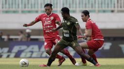 Gelandang PS Tira Persikabo, Osas Saha, berebut bola pemain Persija Jakarta pada laga Shopee Liga 1 di Stadion Pakansari, Bogor, Selasa (16/7). Tira menang 5-3 atas Persija. (Bola.com/Yoppy Renato)
