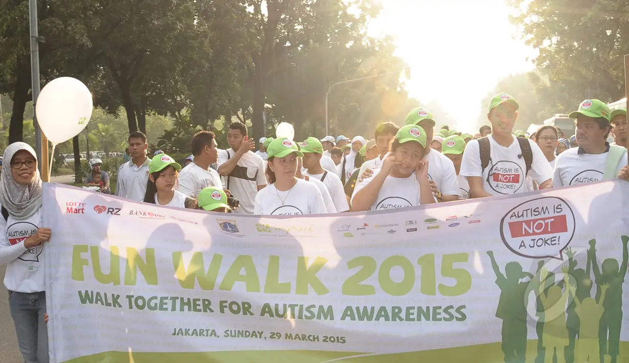 Para peserta fun walk 2015 Autism is not a joke berjalan membawa spanduk di balai kota, Jakarta, Minggu (29/3/2015). acara ini dalam rangka memperingati hari autisme sedunia yang jatuh tanggal 2 april setiap tahunnya. (Liputan6.com/Herman Zakharia)