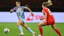 Pemain Timnas Wanita Spanyol, Aitana Bonmati (kiri) berusaha melewati penjagaan pemain Timnas Wanita Swiss, Nadine Riesen pada laga Grup D UEFA Nations League 2023/2024 di The Letzigrund Stadium, Zurich, Swiss pada 31 Oktober 2023 waktu setempat. Laga dimenangkan oleh Spanyol dengan skor 7-1. (AFP/Sebastien Bozon)