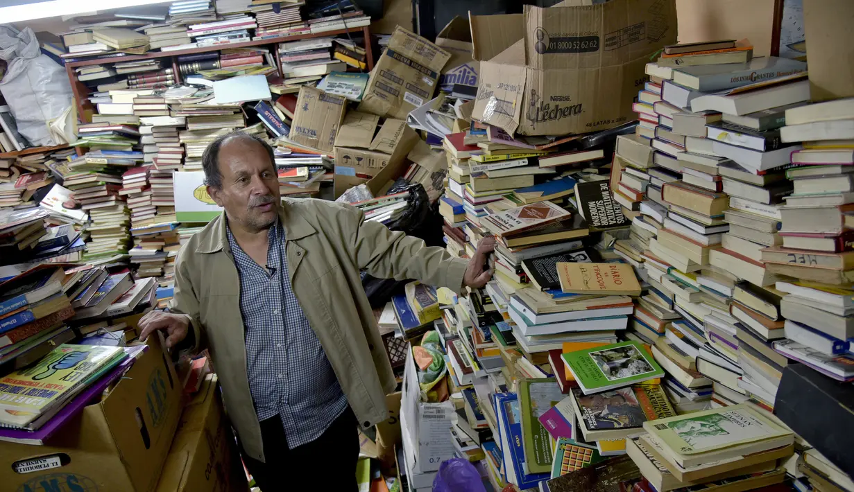 Jose Alberto Gutierrez di antara tumpukan buku-buku koleksinya di perpustakaan rumahnya di Bogota, 18 Mei 2017. Pria asal Kolombia ini sukses membuat perpustakaan dengan mengumpulkan lebih dari 25 ribu buku buangan alias sampah. (GUILLERMO LEGARIA/AFP)