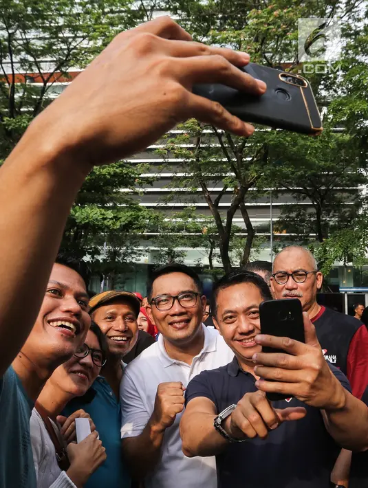 Gubernur Jawa Barat Ridwan Kamil berswafoto bersama warga saat Family Day Artha Graha Peduli (AGP) di Pasar Akhir Pekan SCBD, Jakarta, Minggu (25/11). Emil menyambut positif kegiatan ini sebagai langkah untuk menjaga kesehatan. (Liputan6.com/Fery Pradolo)