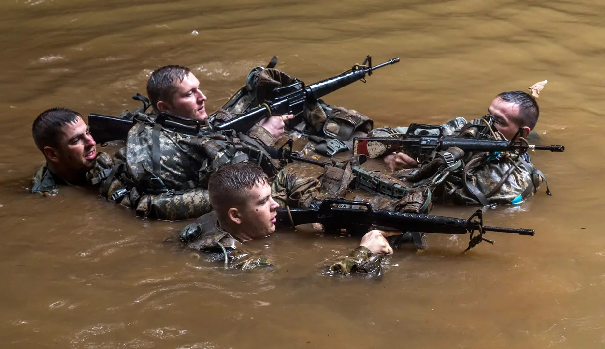 Tentara dari Combat Team Divisi Infanteri 1 Stryker Brigade Angkatan Darat AS menyusuri sungai dalam pelatihan perang hutan di Hawaii, 1 Maret 2017. Tentara Angkatan Darat melakukan kursus pelatihan hutan untuk fokus pada Asia dan Pasifik. (AP/Daniel Lin)