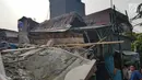 Sejumlah warga melihat rumah roboh di  Jalan Pulo, Tanah Tinggi, Johar Baru, Jakarta Pusa, Jumat (26/4). Hingga saat ini petugas masih melakukan evakuasi warga yang masih terjebak di dalam puing bangunan rumah yang ambruk. (Liputan6.com/Herman Zakharia)
