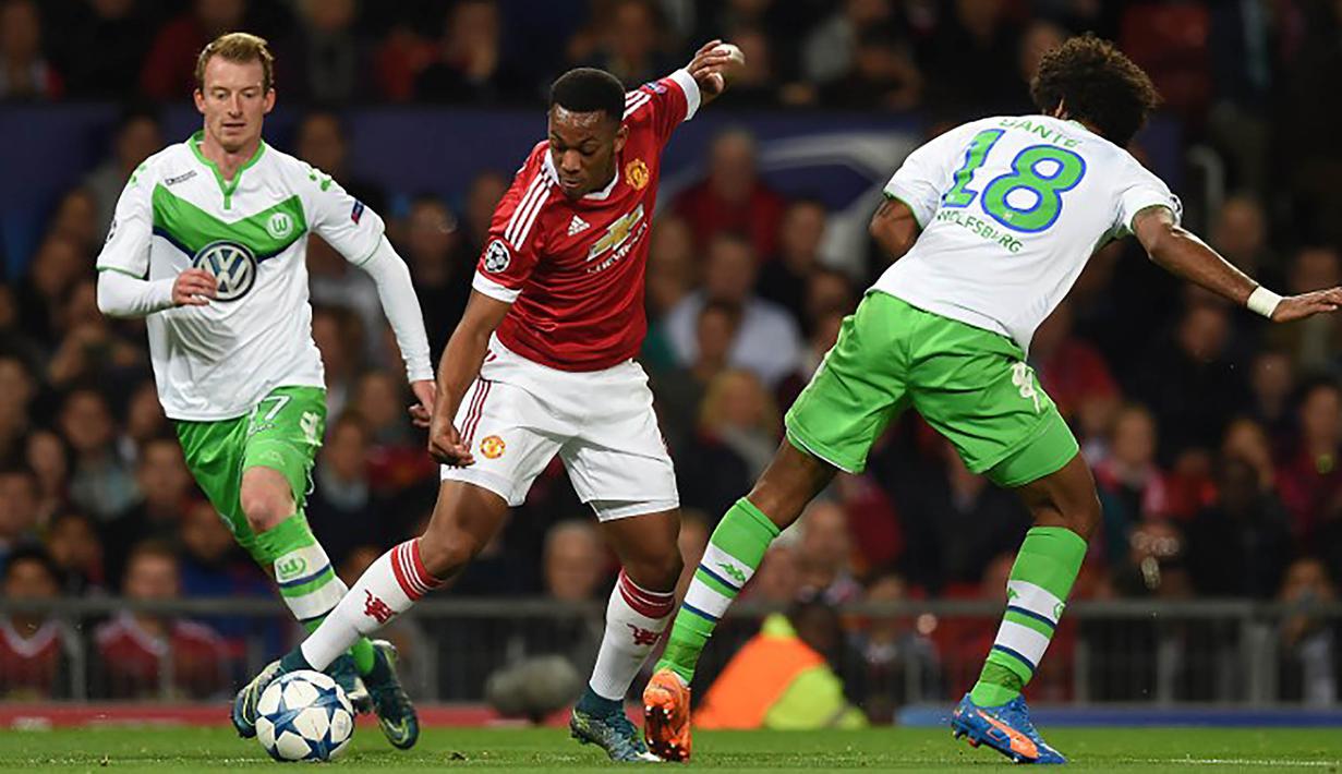Pemain Manchester United, Anthony Martial berusaha melewati pemain Wolfsburg, Dante pada laga Liga Champions di Stadion Old Trafford, Inggris, Kamis (1/10/2015). (AFP Photo/Paul Ellis) 