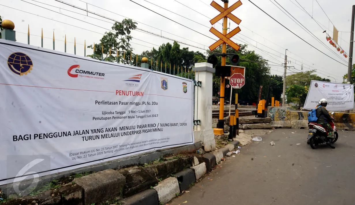 Pengendara motor melintas diantara spanduk sosialisasi penutupan perlintasan KRL Commuter Line sebidang di Pasar Minggu, Jakarta, Selasa (9/5). Penutupan secara permanen akan dilakukan pada 2 Juni mendatang. (Liputan6.com/Helmi Fithriansyah)