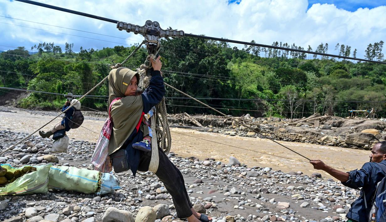 Keberadaan tali sling kini menjadi bagian penting dari kehidupan warga Kecamatan Ketol. Tampak dalam foto, warga menggunakan tali untuk menyeberangi sungai setelah banjir bandang yang menghancurkan desa-desa di sekitarnya di Ketol, provinsi Aceh, pada Selasa 6 Januari 2026. (CHAIDEER MAHYUDDIN/AFP)