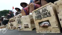 Sejumlah warga Petani Kendeng, Pati, Jawa Tengah menyemen kakinya di depan Istana Negara, Jakarta, Selasa (14 /3). Pada aksi ini di hari kedua ini jumlah petani yang mencor kakinya bertambah menjadi sebelas orang. (Liputan6.com/Helmi Afandi)