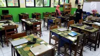 Petugas mengecek kesiapan laptop dan ruang untuk Ujian Nasional Berbasis Komputer di SMP N 34 Pademangan, Jakarta Utara, Minggu (22/4). UNBK SMP 2018 akan berlangsung mulai besok Senin (23/4). (Liputan6.com/Johan Tallo)