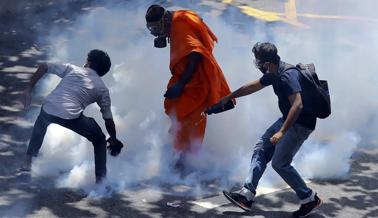 Para pengunjuk rasa bereaksi setelah polisi menembakkan gas air mata untuk membubarkan mereka di Kolombo, Sri Lanka, 9 Juli 2022. Perdana Menteri Sri Lanka Ranil Wickremesinghe meminta pembicara untuk memanggil parlemen, kata pernyataan dari kantor perdana menteri. (AP Photo/Amitha Thennakoon)