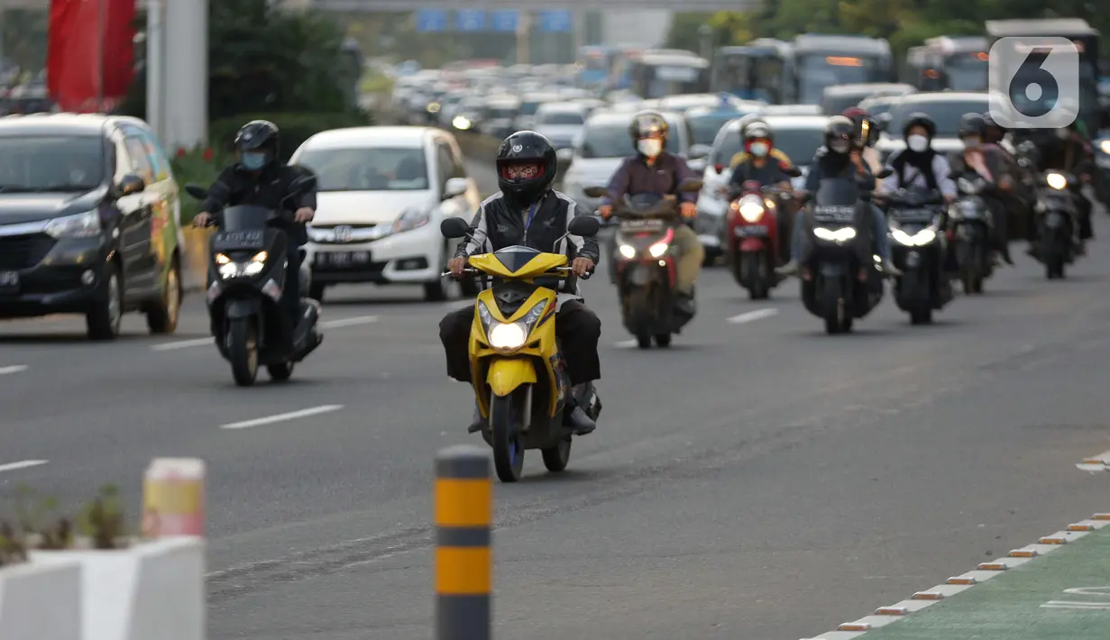 Warga mengenakan masker berkendara melintasi jalan Jenderal Sudirman, Jakarta, Jumat (25/6/2021). Hingga Jumat (25/6), Secara akumulatif Satgas Penanganan Covid-19 mencatat kasus positif Covid-19 di wilayah DKI Jakarta telah menyentuh angka 501.396 orang. (Liputan6.com/Helmi Fithriansyah)