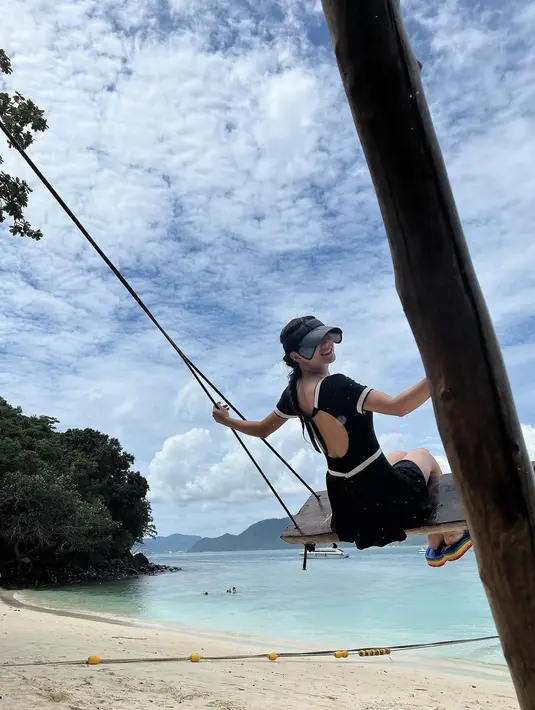 Kim Sae Jong pun saat bermain ayunan di tepi pantai. Cewek 26 tahun ini tampil begitu cantik dengan busana hitam dan topi sambil tersenyum mengarah ke kamera.  (Instagram/clean_0828)