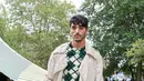 Pemeran The Kissing Booth 2, Taylor Zakhar Perez mengenakan sweater kotak-kotak hijau yang dipadukan dengan trench coat dan long pants warna senada. [Dok/Burberry]