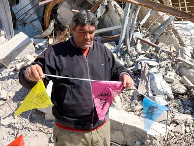 Seorang pria memasang bendera Ramadan di Kota Gaza, di Jalur Gaza tengah pada 28 Februari 2025. (Omar AL-QATTAA/AFP)