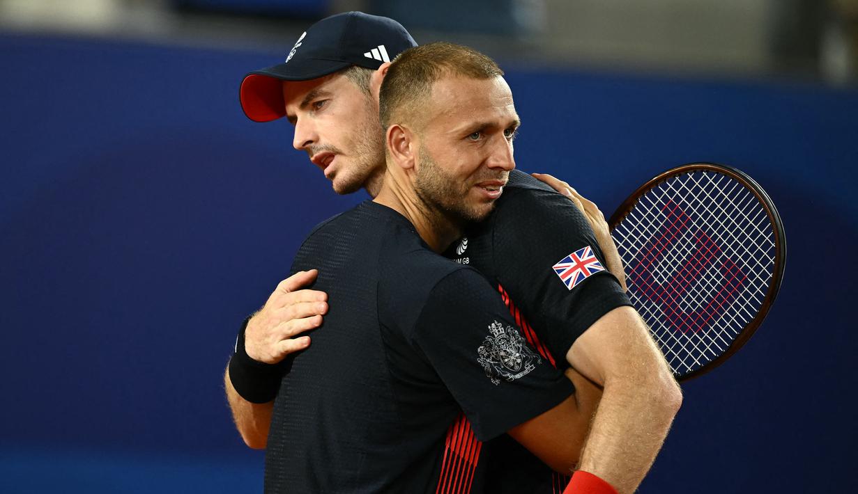 Petenis Inggris, Andy Murray (kanan) memeluk rekannya, Dan Evans saat memberikan salam perpisahan setelah kalah dari pasangan Amerika pada babak perempat final tenis nomor ganda campuran Olimpiade Paris 2024 di Roland-Garros Stadium, Paris, Prancis, Kamis (01/08/2024). (AFP/Carl De Souza)