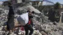 Orang-orang mencari melalui puing-puing bangunan yang runtuh tempat bayi perempuan yang baru lahir ditemukan di kota Jinderis, provinsi Aleppo, Suriah, Selasa (7/2/2023). Bayi perempuan tersebut saat ini menerima perawatan di rumah sakit anak di Kota Afrin. (AP Photo/Ghaith Alsayed)