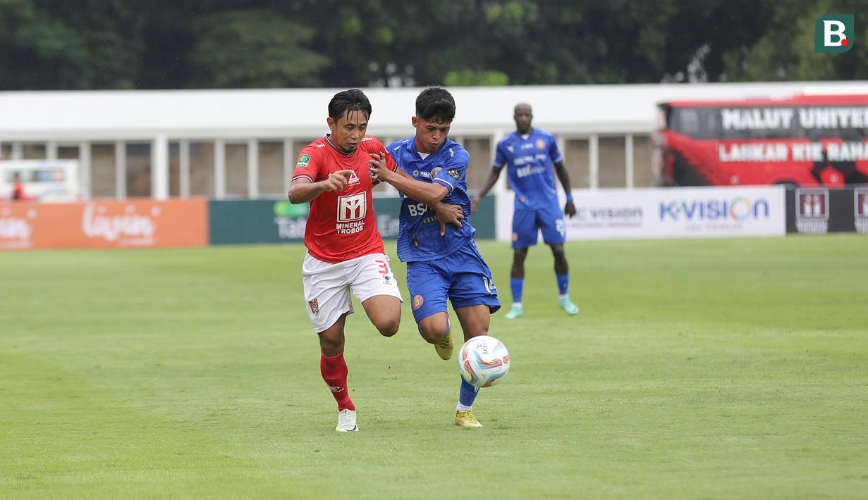 <p>Pemain Malut United, Bagus Nirwanto (kiri) berebut bola dengan pemain Persiraja Banda Aceh, Al Muzanni pada laga leg kedua perebutan tempat ketiga Pegadaian Liga 2 2023/2024 atau playoff promosi Liga 1 2024/2025 di Stadion Madya, Senayan, Jakarta, Sabtu (9/3/2024). (Bola.com/Abdul Aziz)</p>
