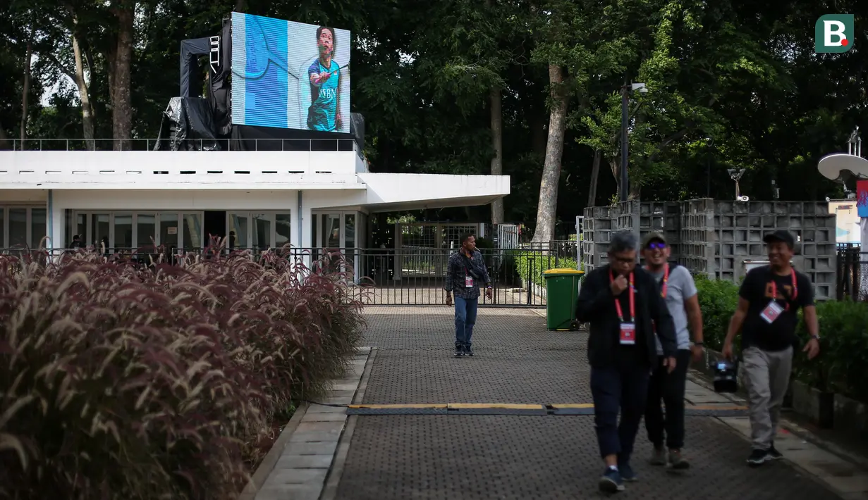 <p>Panitia melewati booth yang berada di suasana Istora Senayan, Jakarta menjelang Indonesia Masters 2023 pada Senin (23/01/2023). Ajang ini nantinya akan berlangsung dari 24 hingga 29 Januari 2023. (Bola.com/Bagaskara Lazuardi)</p>